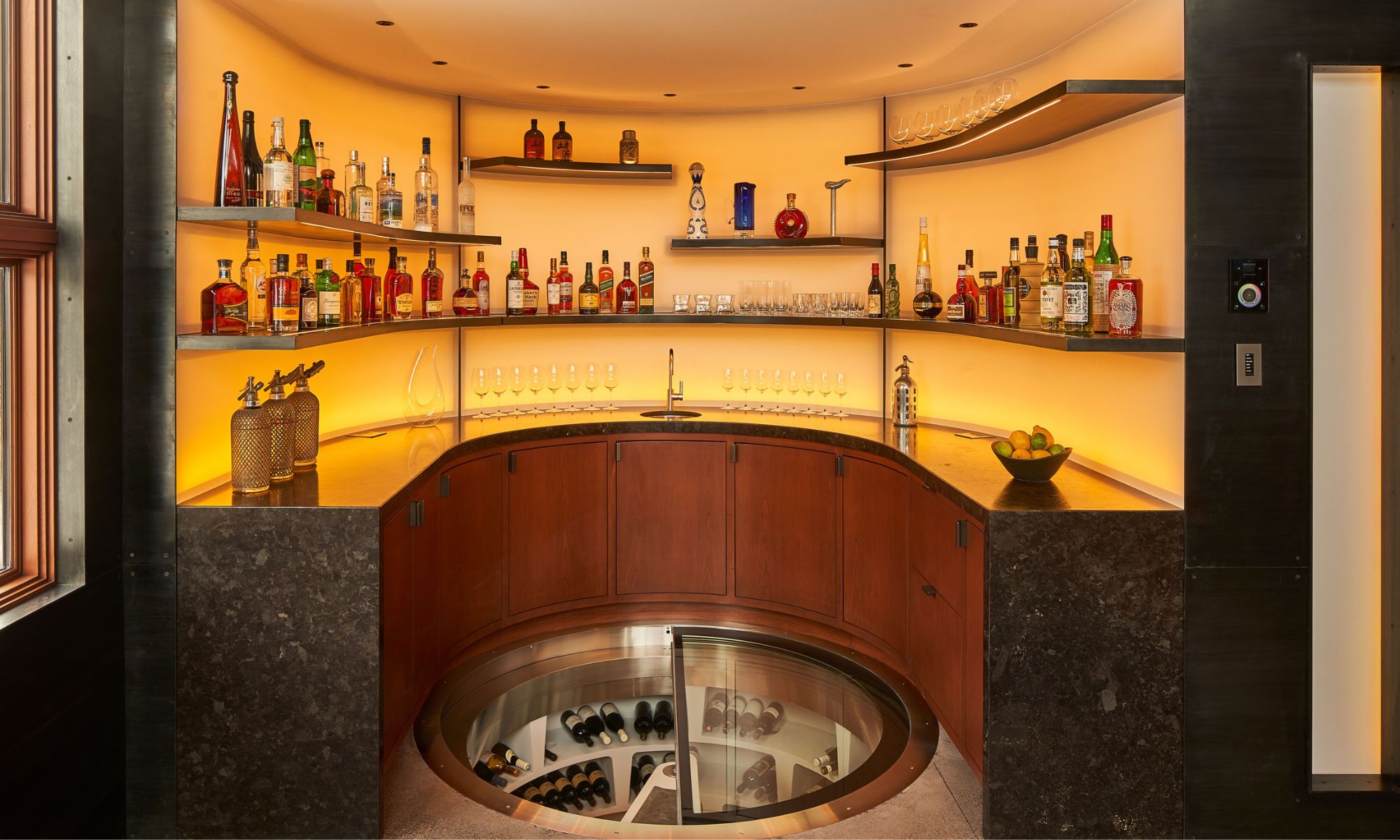 Modern home wine cellar with glass spiral storage, backlit shelves, and assorted bottles