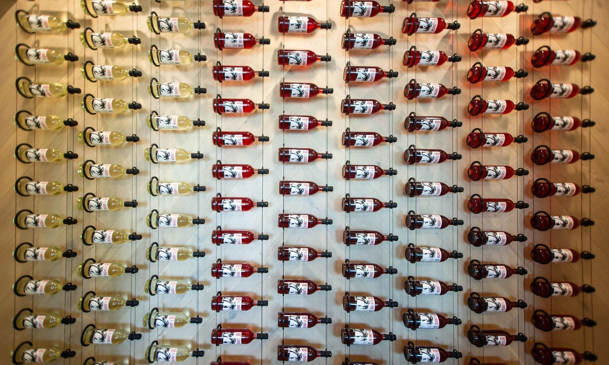 Modern wine wall with rows of red and white bottles in a luxury wine rack display.
