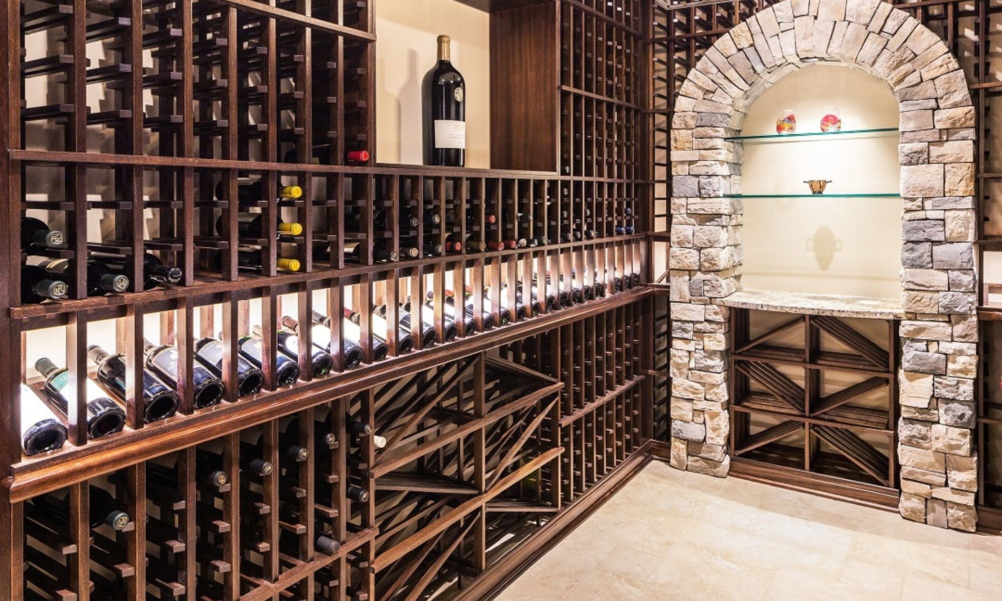 Luxury wine cellar with wooden racks, stone accent wall, and organized wine bottle display.