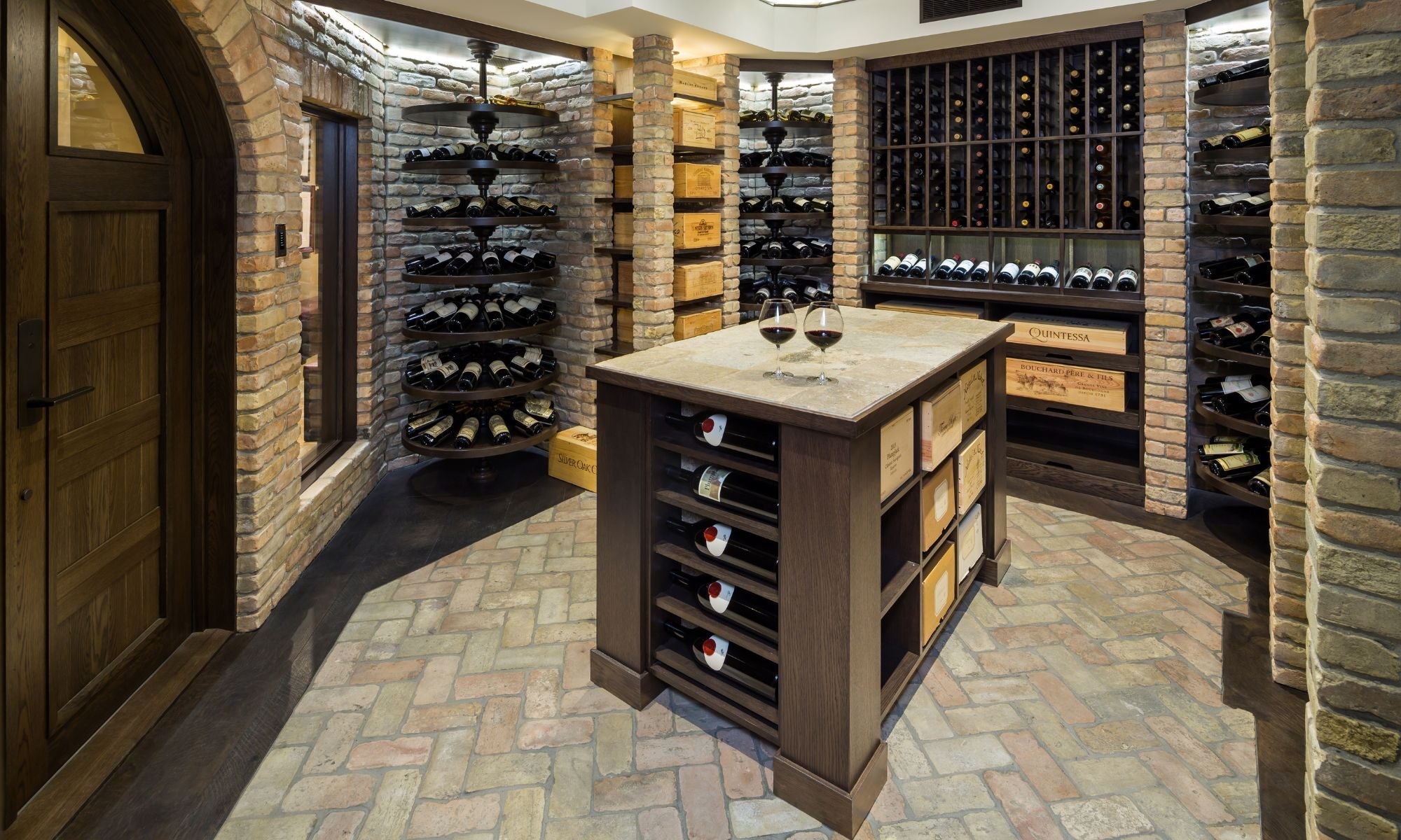 Luxury wine cellar with custom racks, brick walls, and a wooden island for wine storage