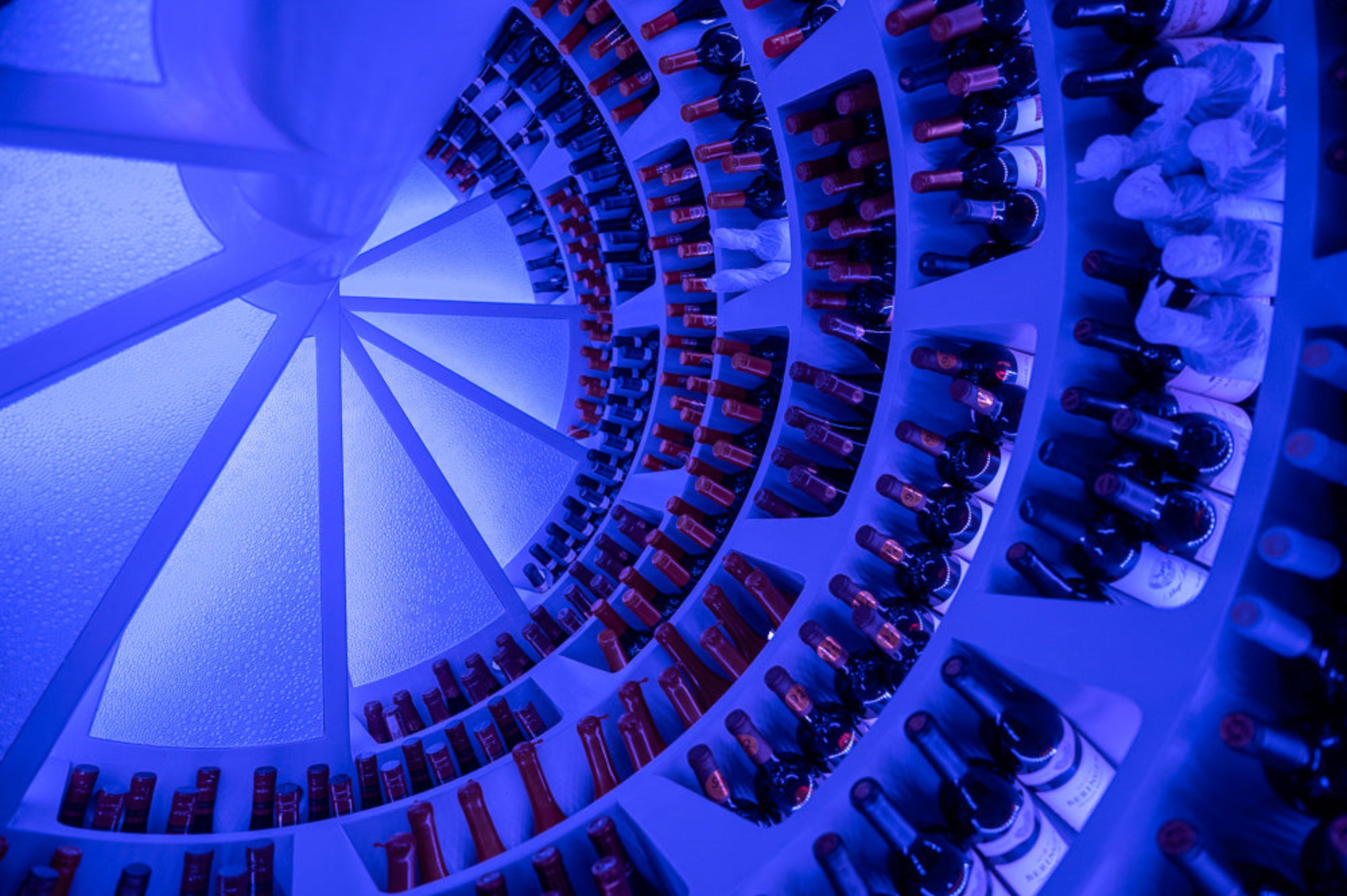 Wine bottles arranged in a circular pattern on a blue background