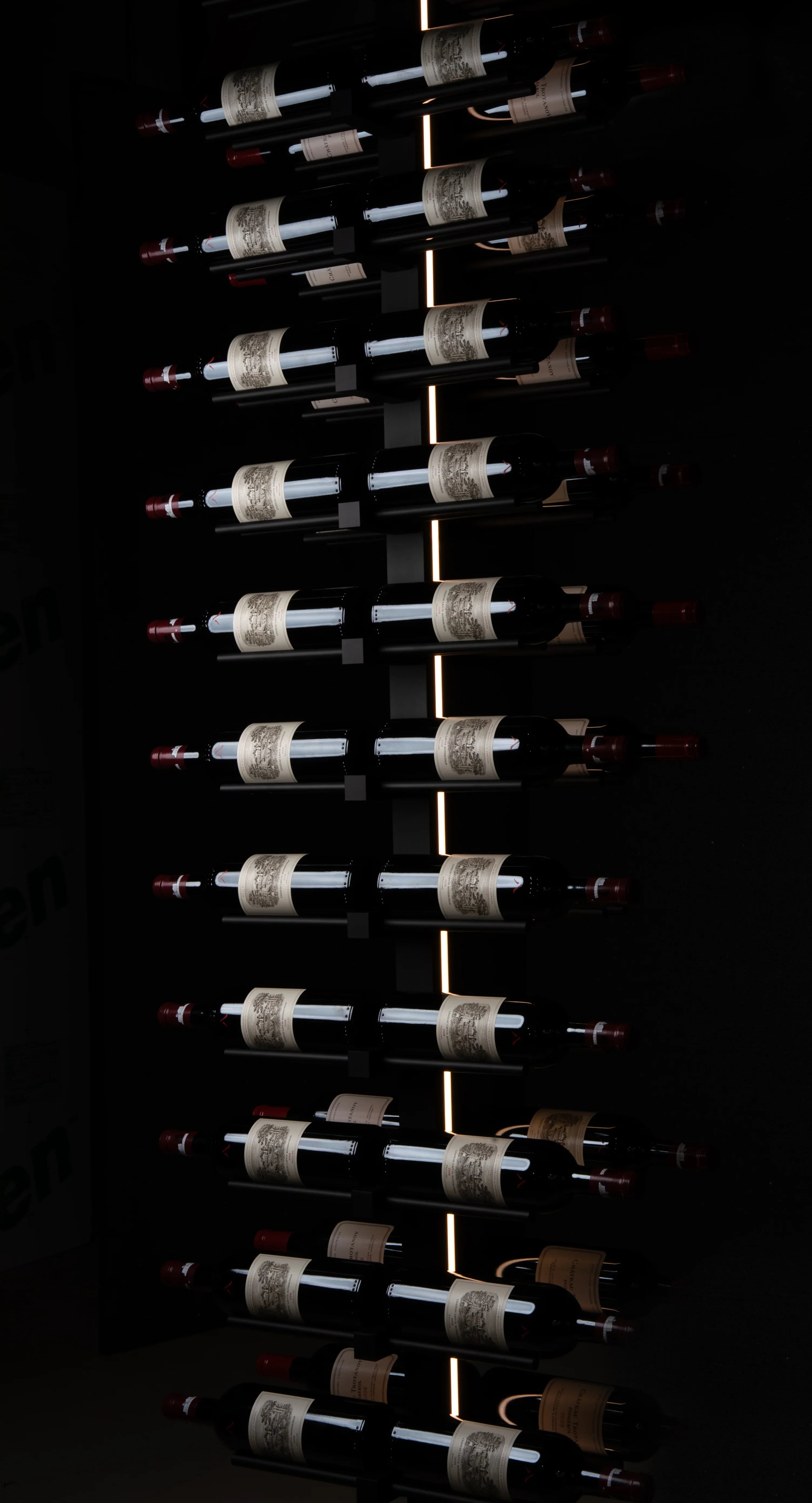 Row of wine bottles on a rack in a dark setting