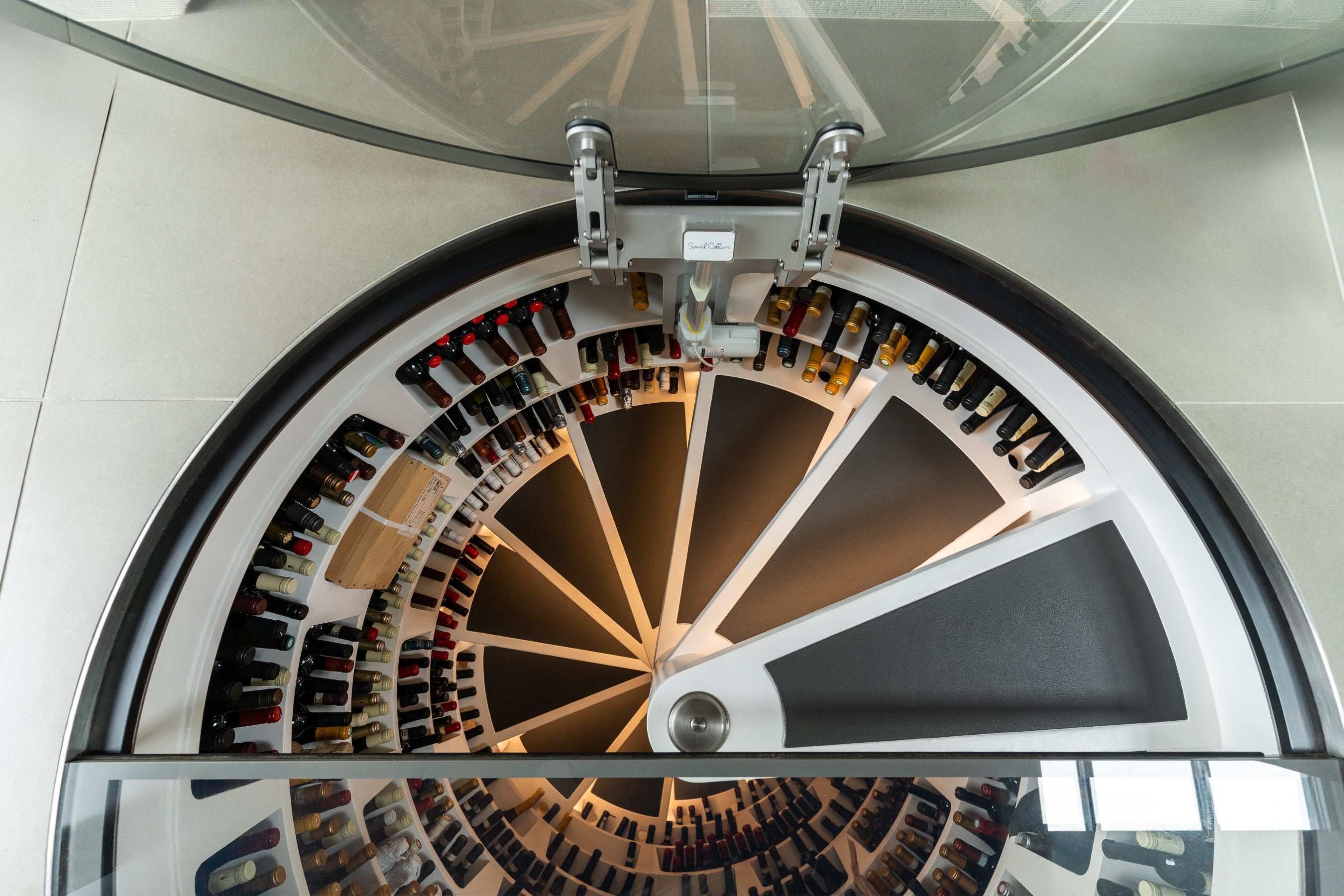 Spiral wine rack with bottles inside a modern kitchen.