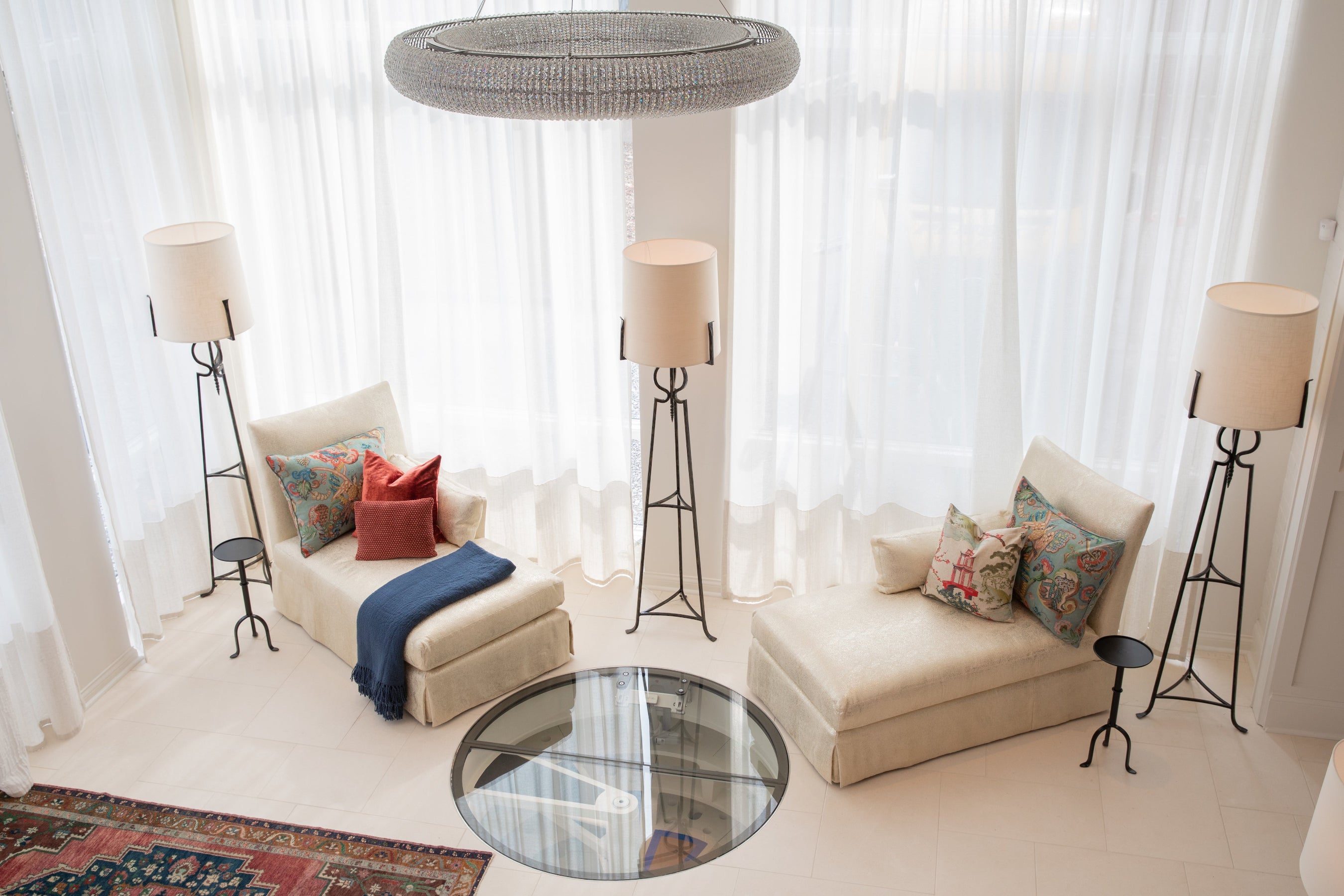Modern living room with beige sofa, decorative pillows, and floor lamps.