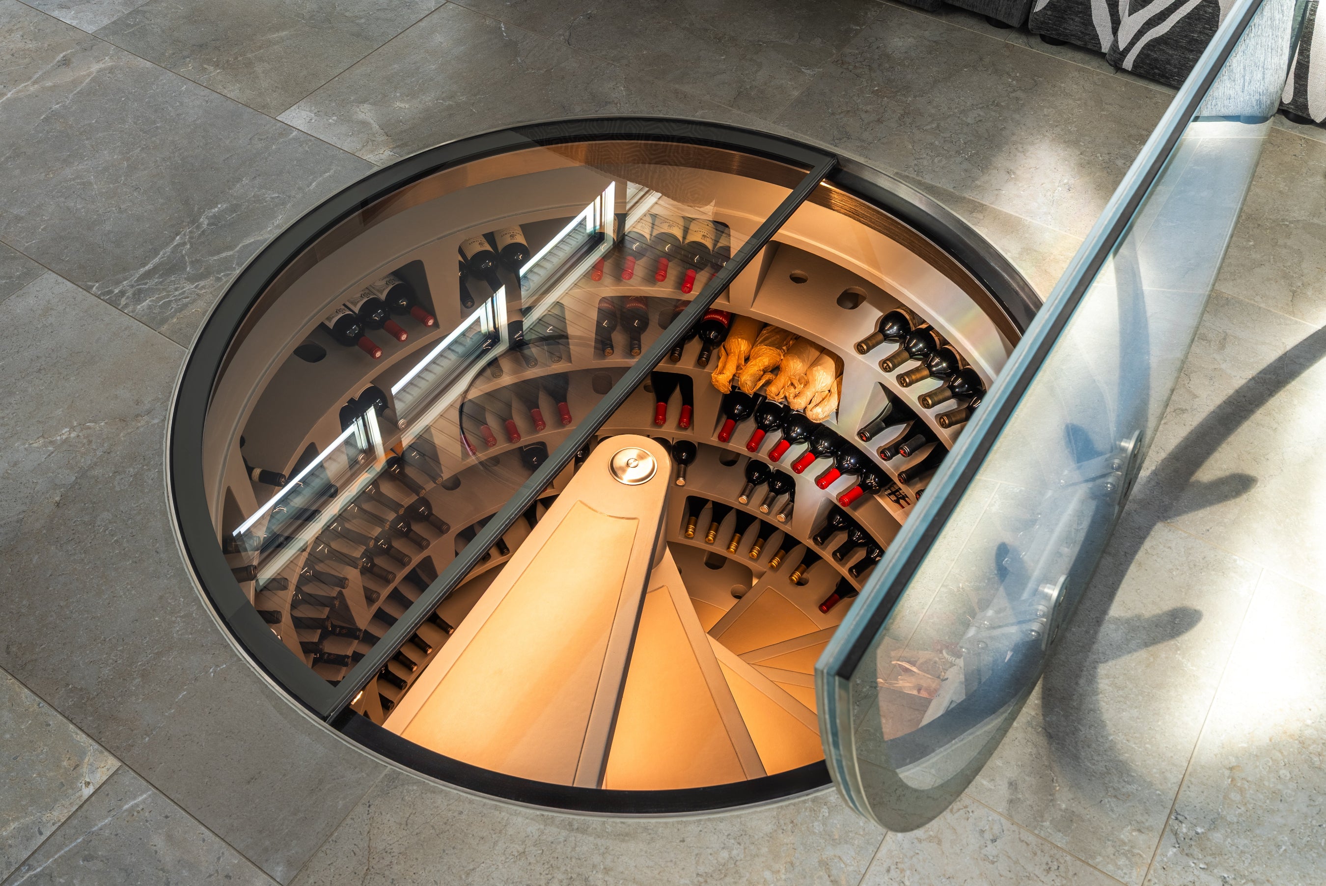 Spiral wine cellar with glass cover on a stone floor